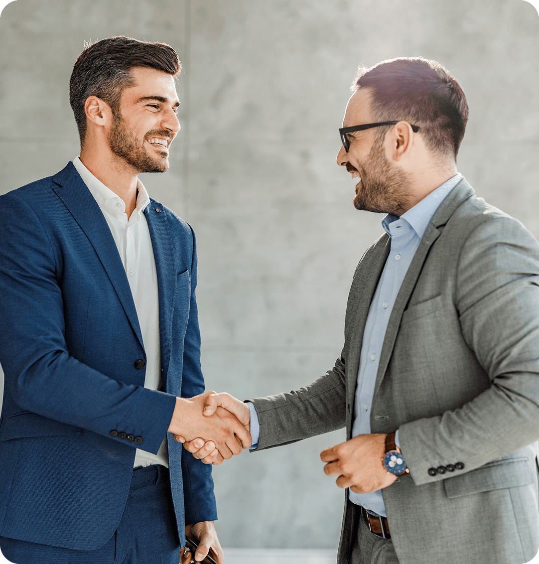 Two businessmen shaking hands smiling